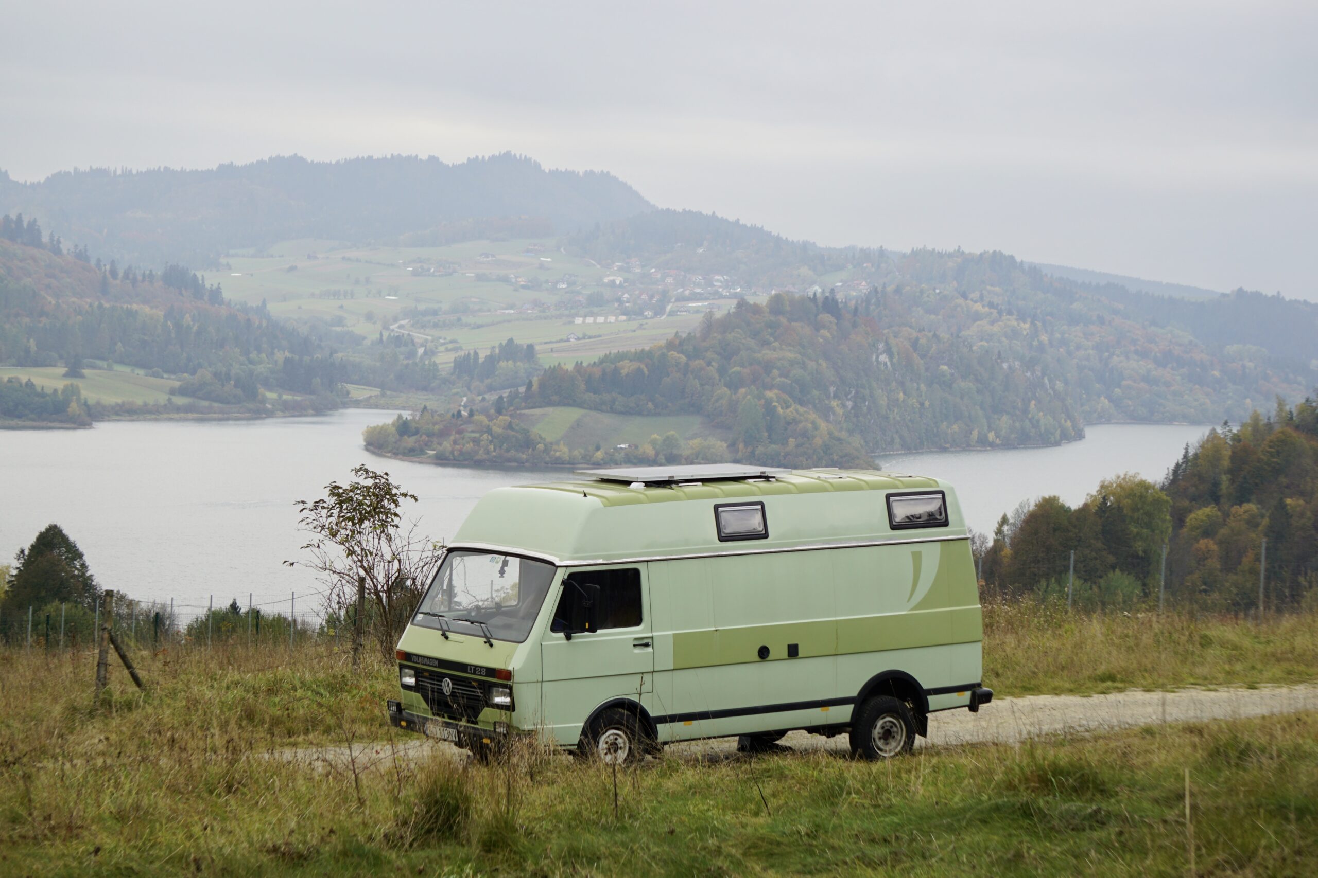 campervan Volkswagen na tle jeziora i gór